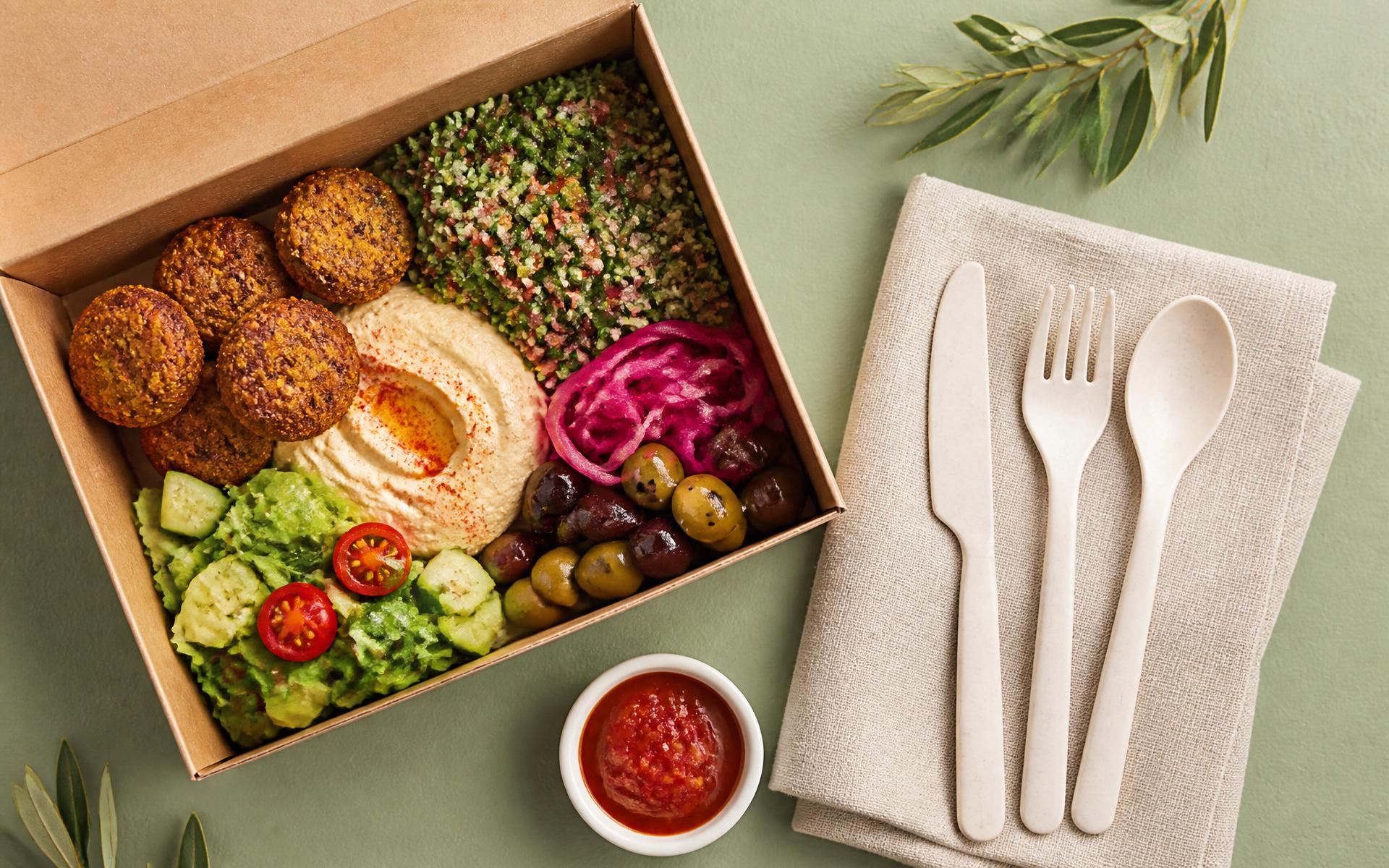Sustainable takeaway meal alongside NÜ bio-calcium cutlery on linen